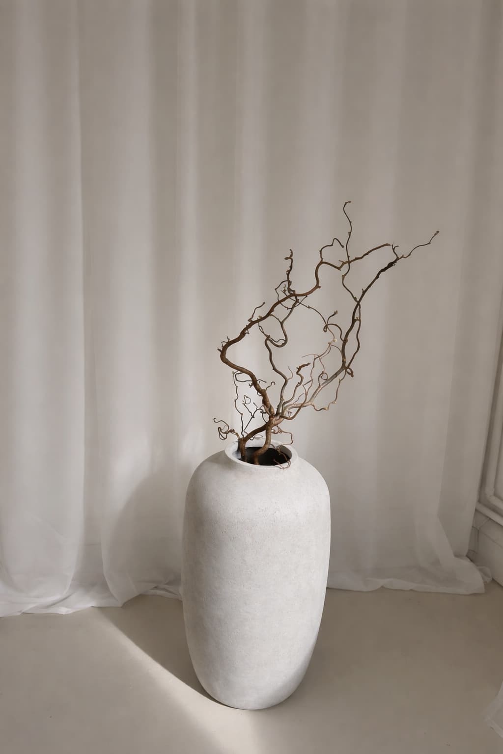 Ceramic vase with dried branches in natural light