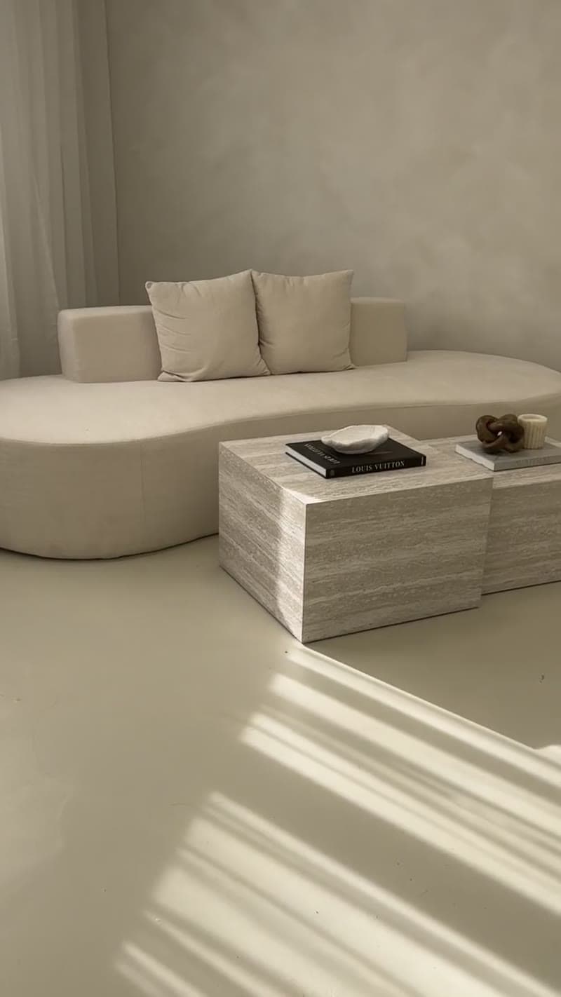 Curved sofa and styled coffee tables in natural light